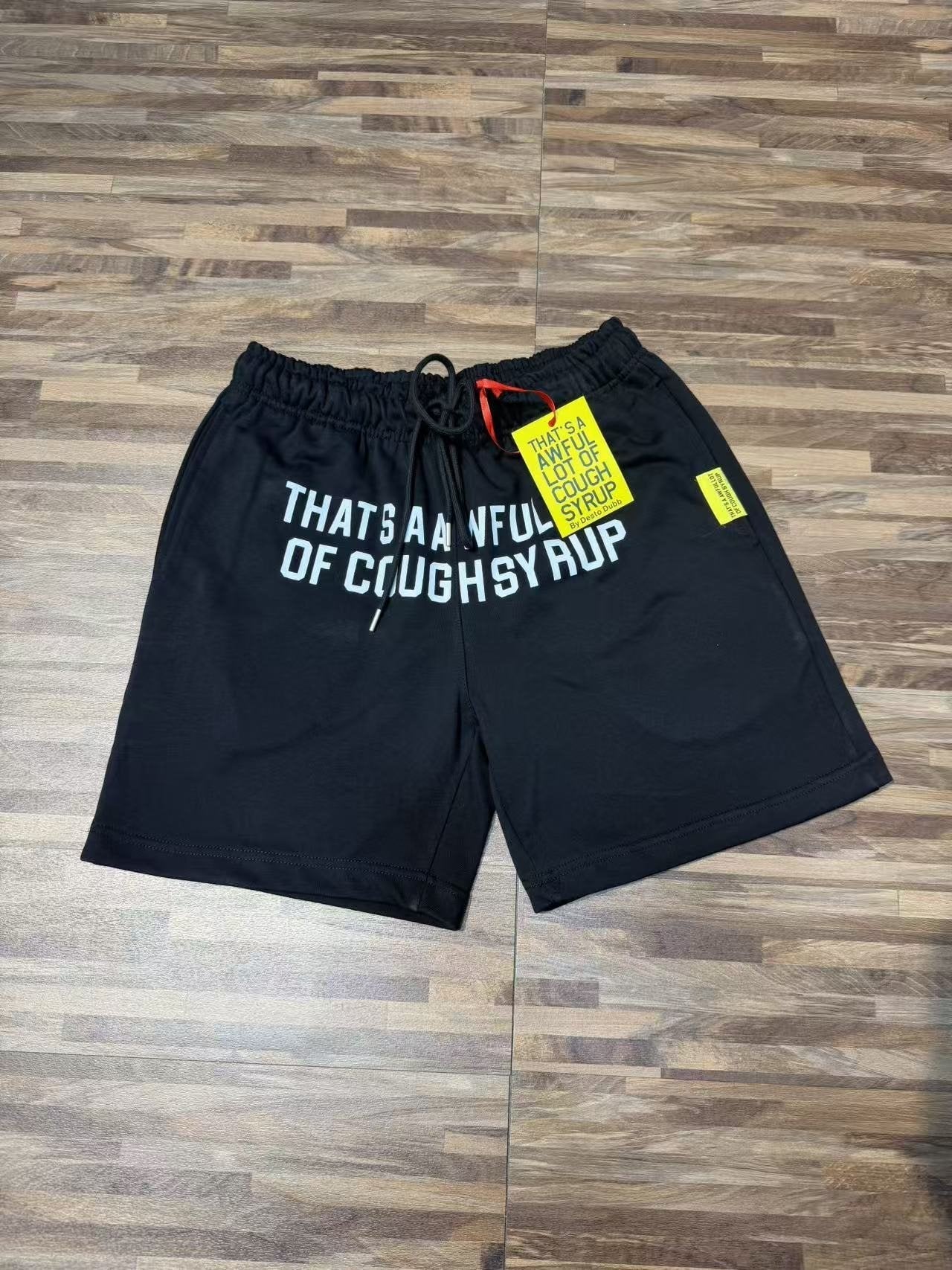 THAT'S A AWFUL LOT OF COUGH SYRUP Black Graphic Shorts — front